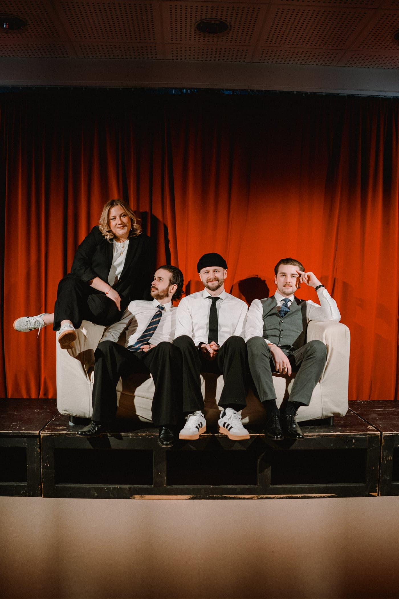 Die Band auf einer Bühne vor rotem Vorhang