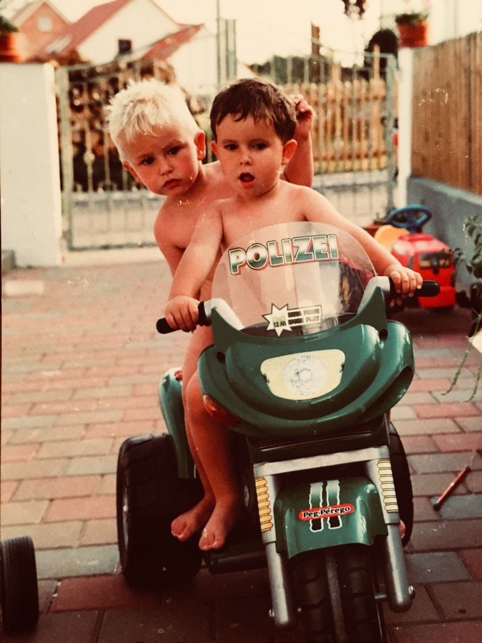 Zwei Kinder auf einem Spielzeugmotorrad
