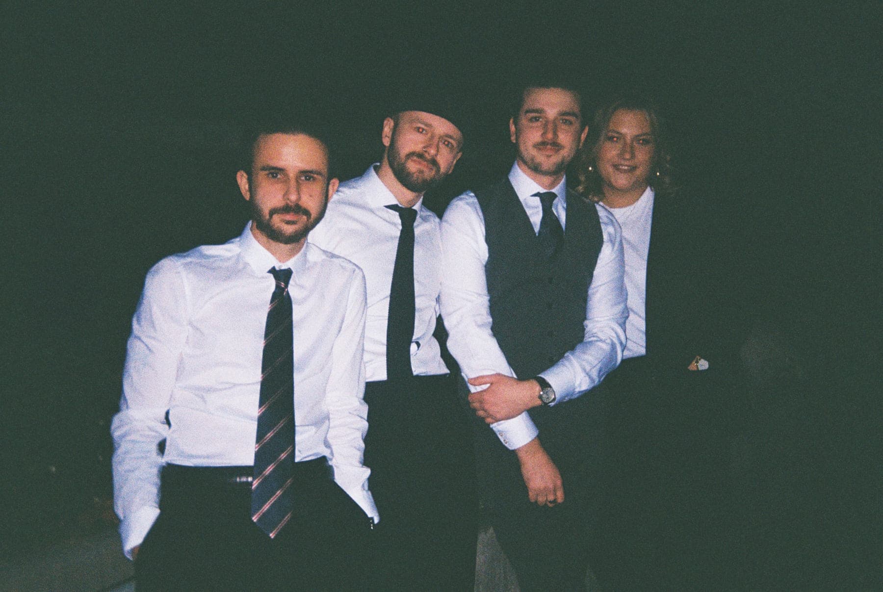 Die vier Bandmitglieder in Hemd und Krawatte